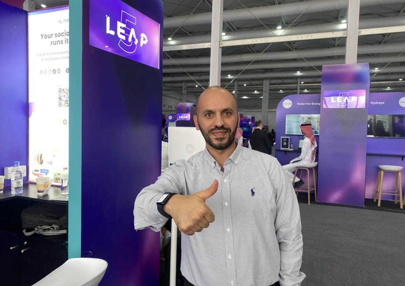 سري السباتين عند جناح LEAP 5 في الرياض، يرفع إبهامه خلال فعاليات LEAP 2026